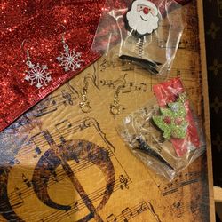 A pair of silver snowflake earrings, a gold snowman and two Christmas hairpins 