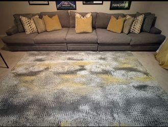 Gray sofa with 10 pillows and 5x7 rug