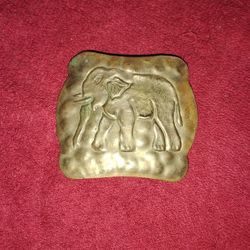 silver-toned elephant-themed item, likely a brooch, pin, or pendant. 