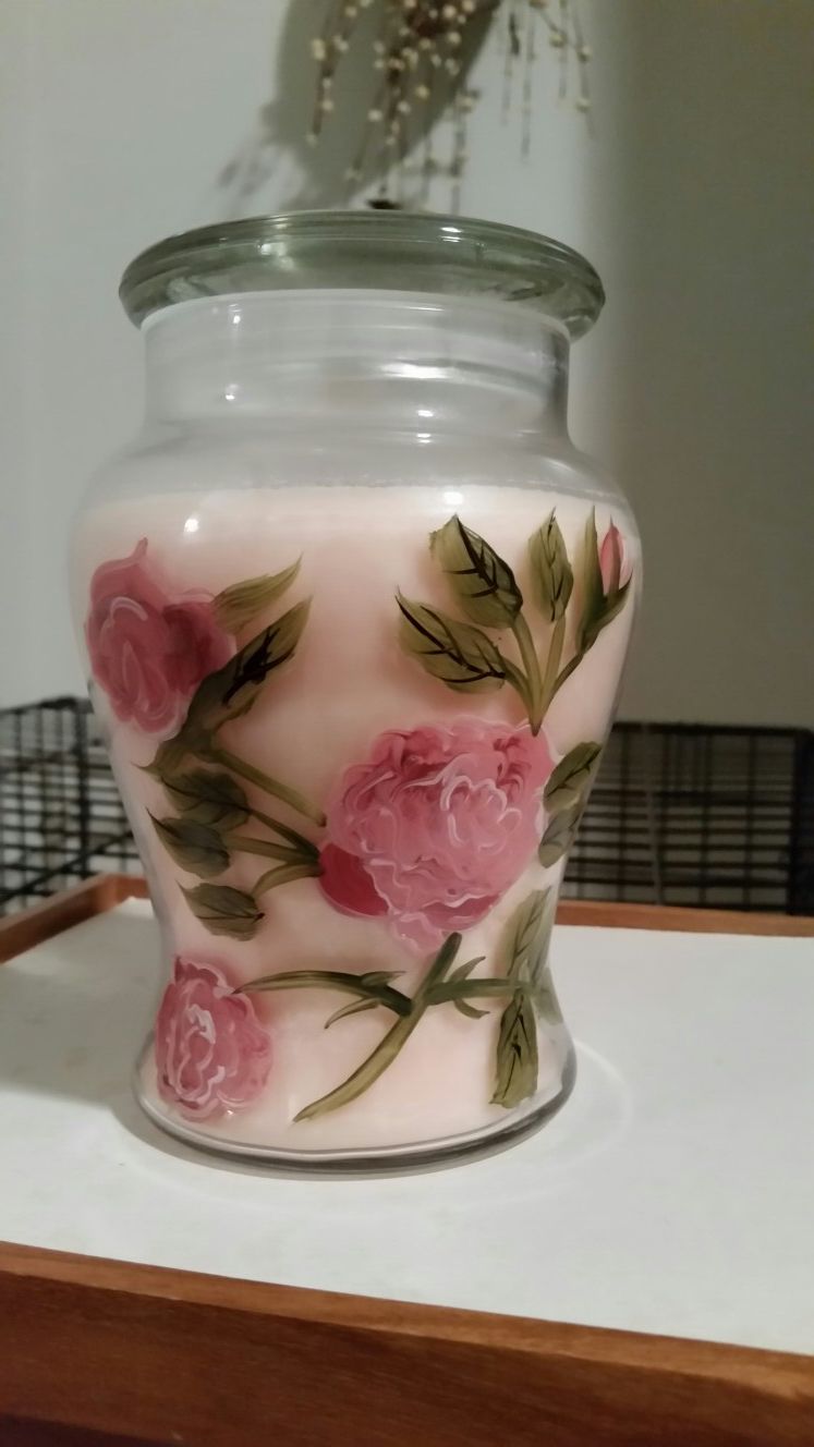 Pink candle in floral painted glass jar