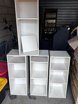 Four bookshelves or storage shelves. Approximately 12 inches deep and 12 inches across by 31.5 tall