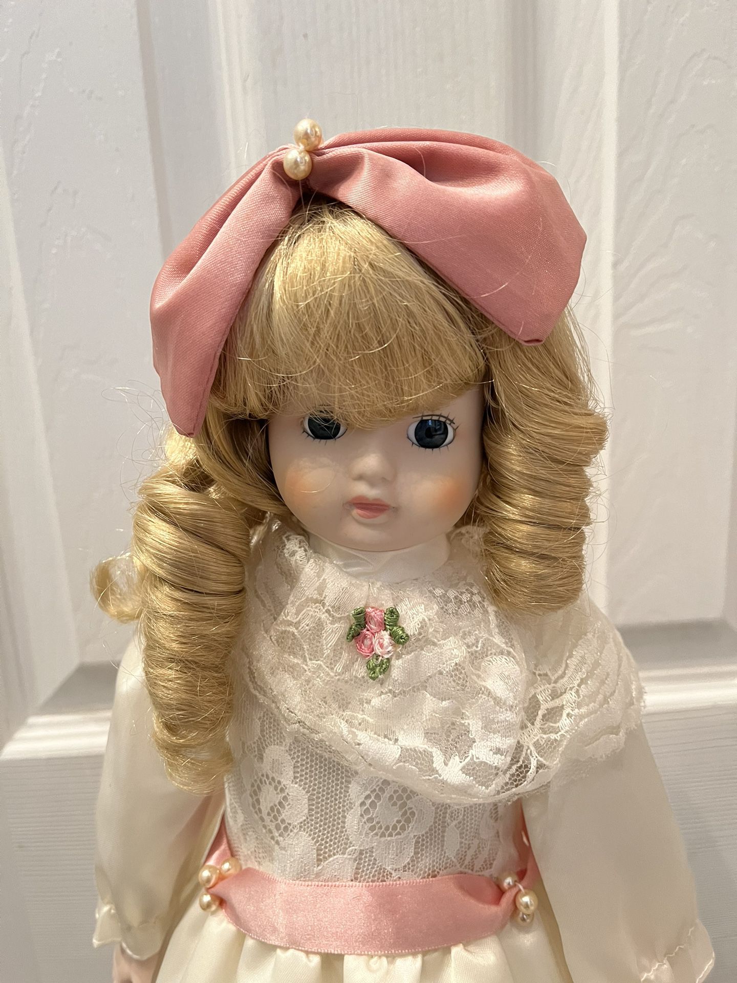 Porcelain Doll With Satin Dress, Pink Bowes , Ribbon And Lace And White Pearls.  Blond Ringlets, White Petticoat And White Laced Shoes. 