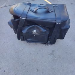 The item in the image is a motorcycle touring bag, also known as a sissy bar bagThe bag has a two-piece design, featuring a large main bag and a small