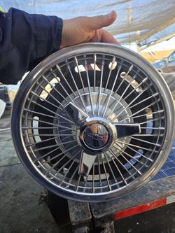 Chevrolet wire spoke spinner hubcap, commonly used on models such as the Chevy II, Corvair, or Impala from the mid-1960s. 