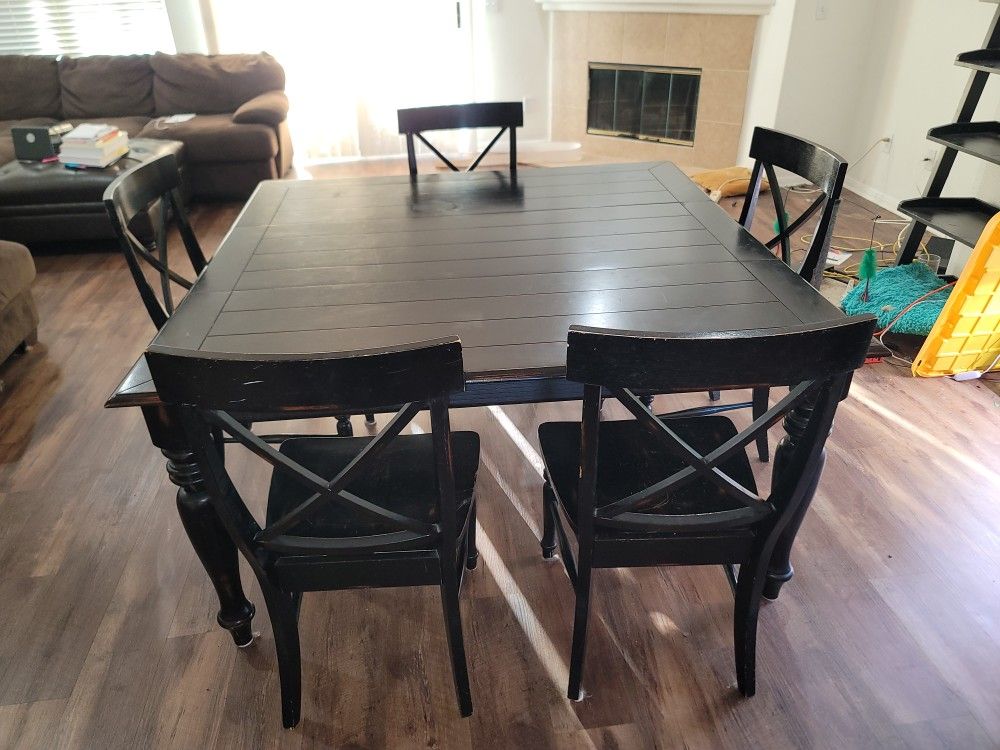 large solid wooden dinner table with five chairs