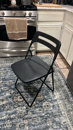 One black IKEA folding chair