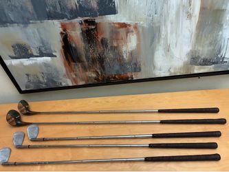 Vintage lot of 5 Tom Stewart golf clubs- 2 persimmon wood woods(1, 3) and 3 Stainless Steel irons (5, 6, and 7).