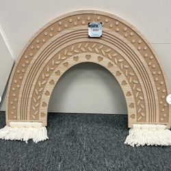 Wooden rainbow wall decor with heart and leaf patterns.