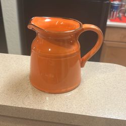 Cream Colored, Dual Wood Wick In An Orange Pitcher Container