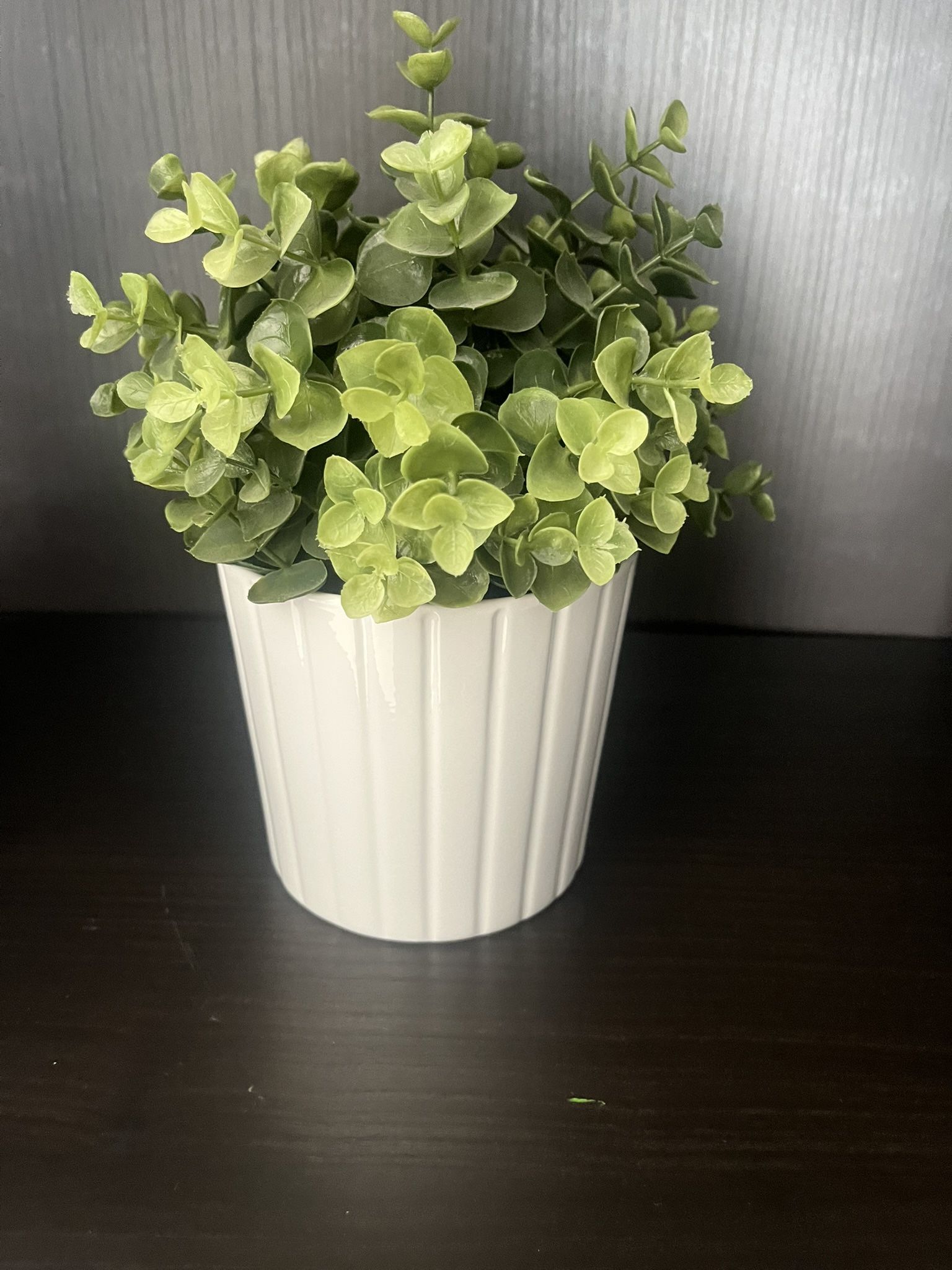 White vase with green fake plants