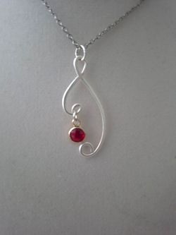 Silver wire-wrapped pendant necklace with red gemstone