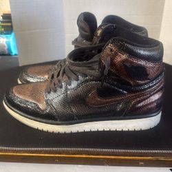 Women's Nike Air Jordan 1 Retro High OG "Fearless" sneaker in a black and metallic rose gold colorway. 