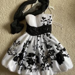 Short, Sleeveless White Prom Dress with Black Floral Accents and Sheer Black Scarf