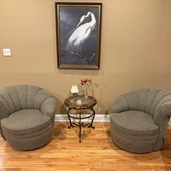 The two matching beige / black upholstered swivel tub chairs 