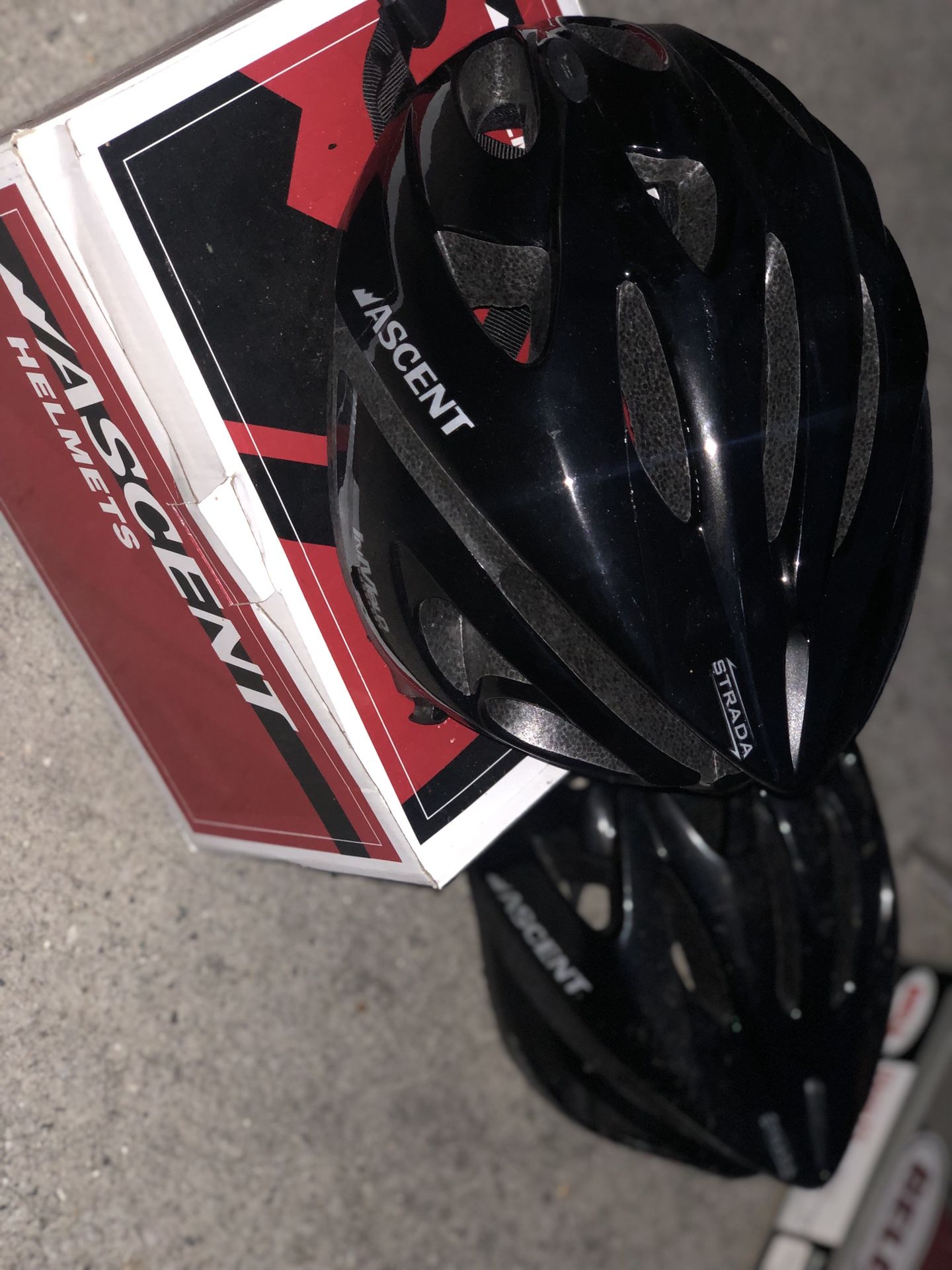 Two Strada bicycle helmets and one bell bicycle helmet