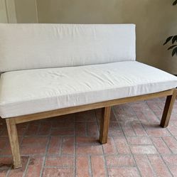 Outdoor wooden bench sofa with white pillows