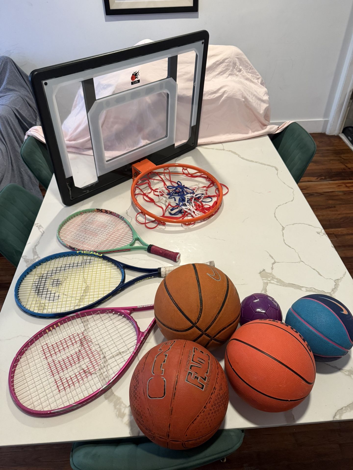 Sports kit with tennis rackets, basketball hoop, and balls