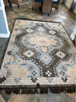 This Safavieh Aspen Collection wool rug features a tribal-inspired design in light blue and grey tones.