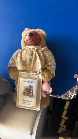 vintage 1990 Robert Raikes "Courtney" teddy bear featuring a carved wooden face, jointed plush body, and floral nightgown, shown alongside its origina