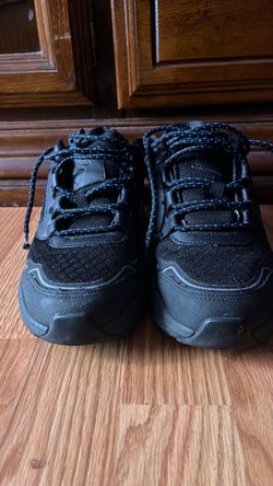 black low-top sneakers with blue laces