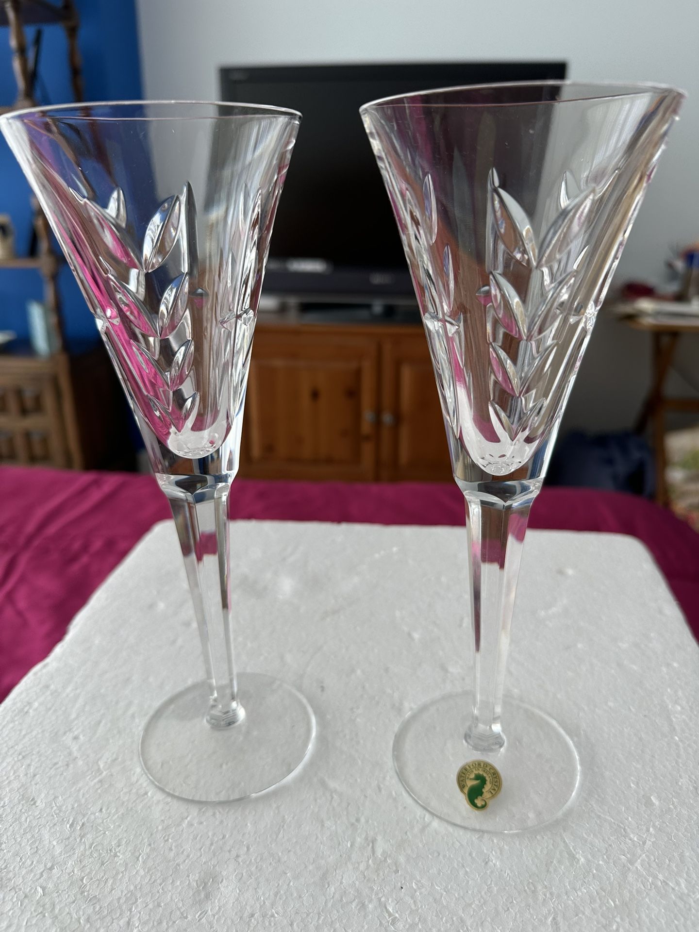 pair of Waterford Crystal champagne flutes—Heritage collection.  both embossed w Waterford on base.  one has foil on base as well.