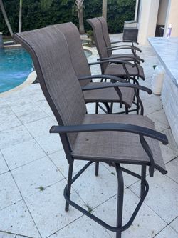 4 brown and black outdoor bar stools