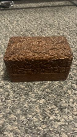 vintage jewelry box with floral carvings and two compartments inside.