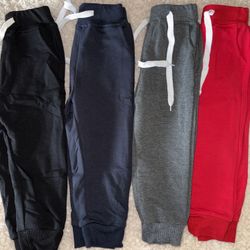 New set of comfy toddler pants. Got 4 pairs: black, navy, grey, and red. All have white drawstrings and elastic cuffs. Still in packaging!
