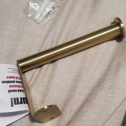 Wall-mounted gold single-arm toilet paper holder.
