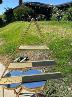 gold metal triangular floating shelf features three tiers and has a modern design