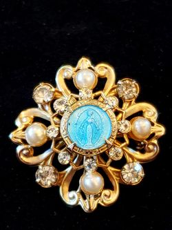 $10. Baby blue vintage religious faux pearl and rhinestone gold tone brooch. 1.25 inch diameter.