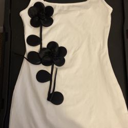 white mini dress featuring black 3D floral appliqué decorations and a hem slit