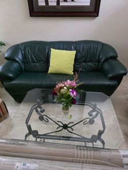 Green leather sofa and matching glass table