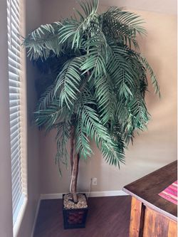 Large artificial palm tree with decorative pot and lights