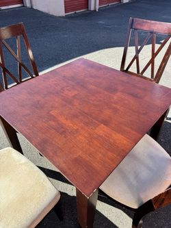 Square wooden table and four chairs