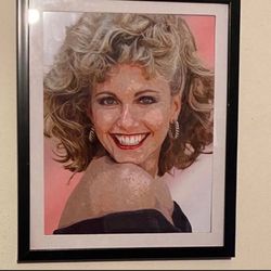 Custom art piece of Olivia Newton John from the film grease in black frame