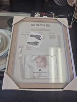Wendy Bellissimo "All About Me" keepsake frame features a light wood finish and allows you to display a baby photo, footprints, and birth details.