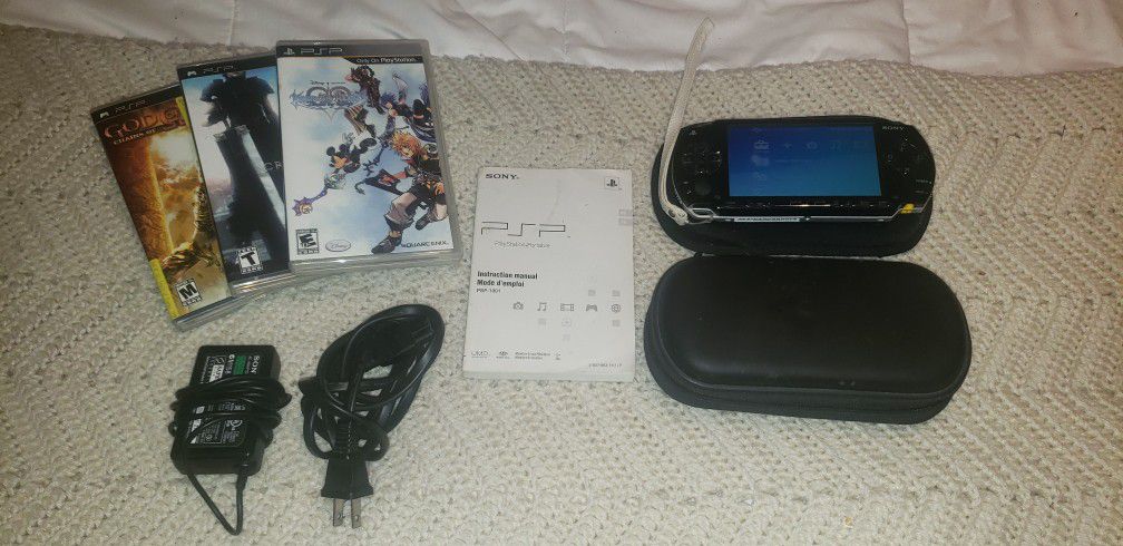 Sony PSP Console w/ x2 cases, charging chords, instructions, and x3 games