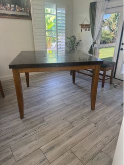 Marble dining table with 6 chairs and a storage bench.