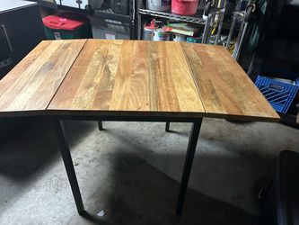 Drop leaf butcher block table with black metal frame and legs