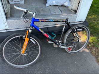 vintage GT mountain bike, likely featuring a Manitou suspension fork and a dual-tone paint scheme.