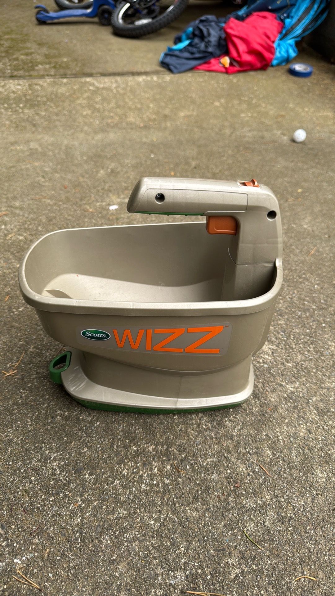 Scotts Wizz Spreader — a handheld battery-powered spreader used for grass seed, fertilizer, weed control, ice melt, and similar lawn products.