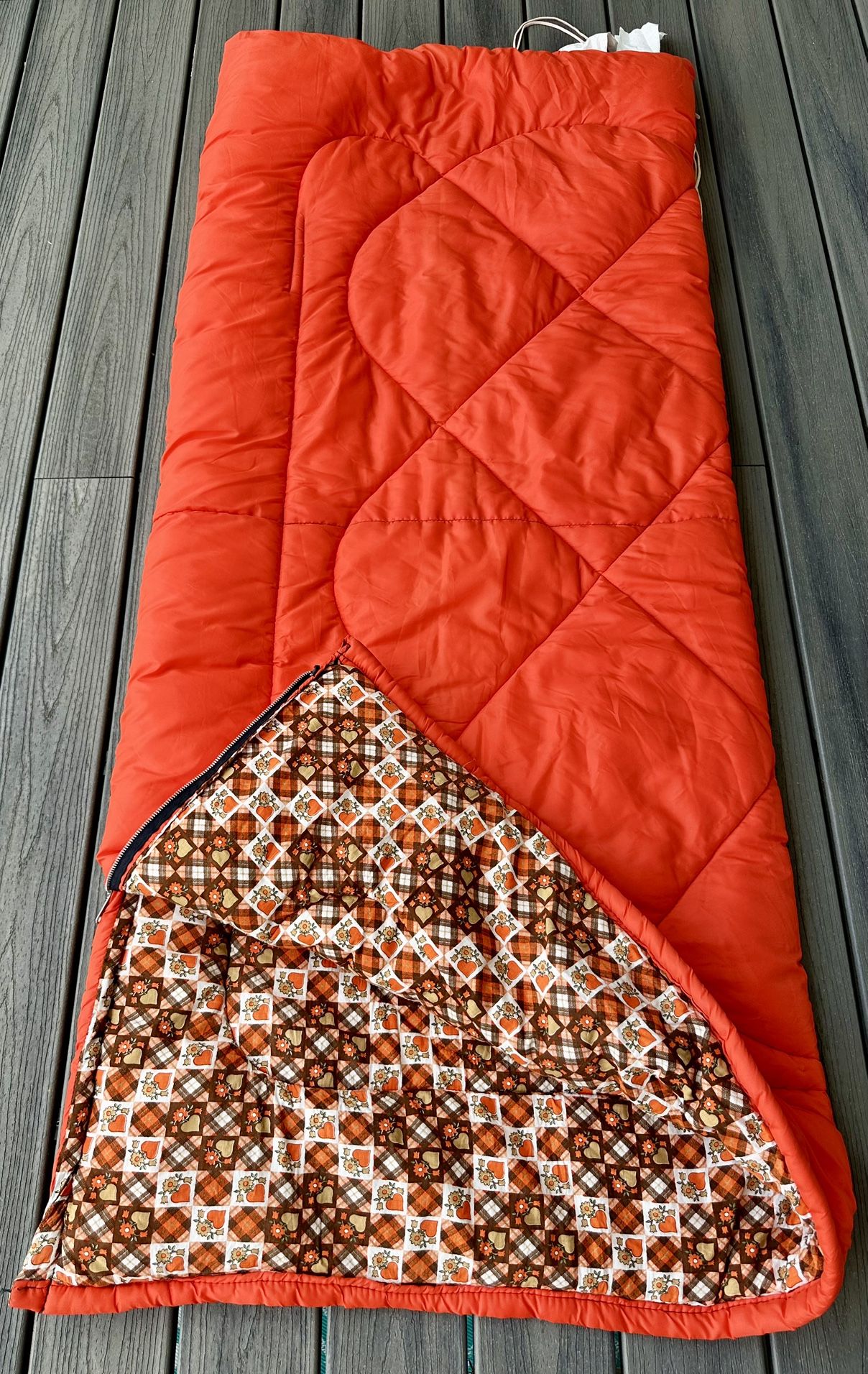 Vintage ‘76 Coleman sleeping bag Bright orange 100 % nylon outside that reverses to plaid patchwork 100 % cotton soft fabric in retro orange / brown 