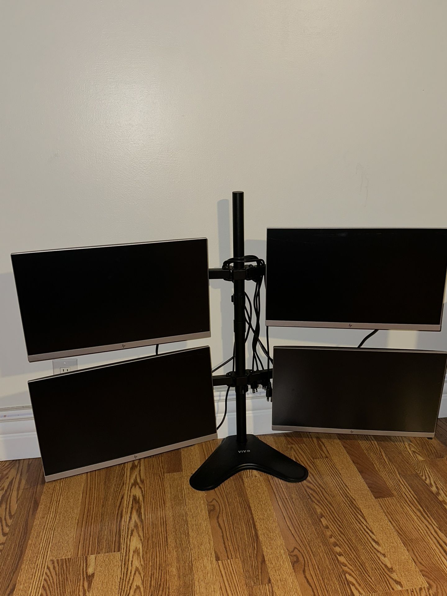 four HP silver monitors, each 24 inches, mounted on a VIVO quad monitor stand. 