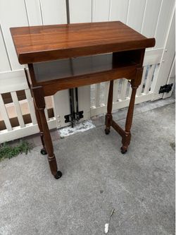 Vintage walnut book stand on wheels. Great condition