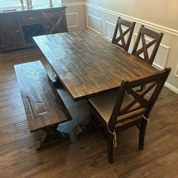 Beautiful solid wood farmhouse dining table with matching bench and chairs. This set is sturdy, well-made, and has a gorgeous rustic finish that fits 