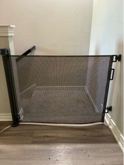 Retractable baby gate with lock