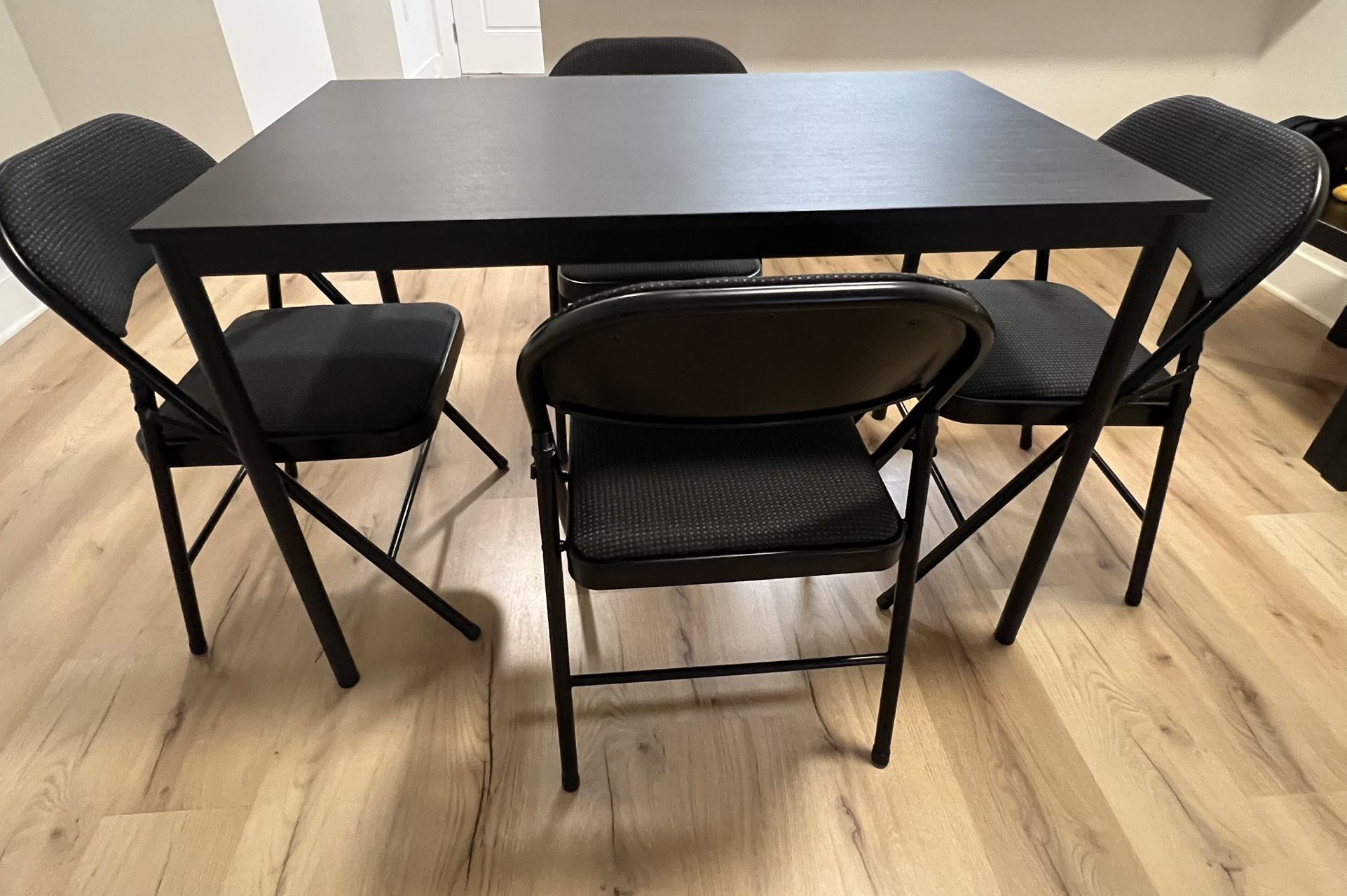 Dining table with four cushion folding chairs
