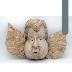 This product is a handmade Mexican wood carving of an angel with glass eyes. The angel is designed to be a windblower, and is likely used for decorati