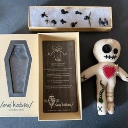 The kit includes a voodoo doll, a coffin-shaped box, and pins